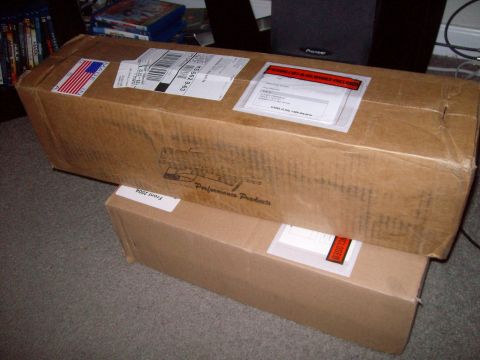 2004 Ford Crown Victoria - Cardboard boxes, one with 'Front 2004' and 'Performance Products' labels, are stacked indoors.