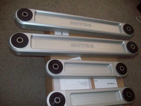2004 Ford Crown Victoria - Four control arms with black bushings are displayed, each the 'METCO' brand name.