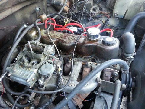 1981 Ford Bronco - Close-up view of an engine bay a carburetor and various hoses and wires.