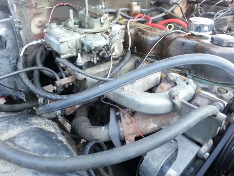 1981 Ford Bronco - Close-up view of an engine bay, focusing on the carburetor and associated plumbing.