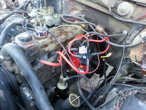 1981 Ford Bronco - A close-up view of a vehicle's engine compartment, showing the carburetor and ignition system.