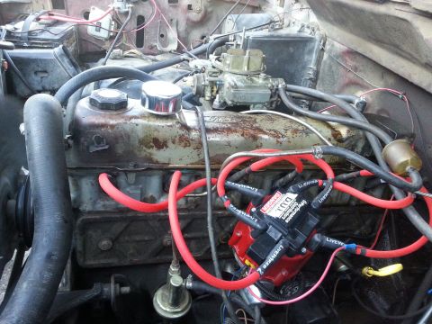 1981 Ford Bronco - Close-up view of a V8 engine bay a carburetor and red spark plug wires, with a DUI ignition system installed.