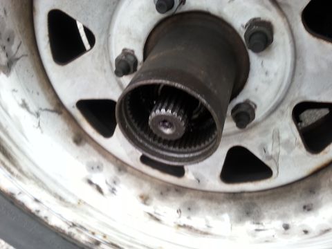 1981 Ford Bronco - Close-up of a vehicle's wheel hub assembly, showing internal splines and a dirty steel wheel.