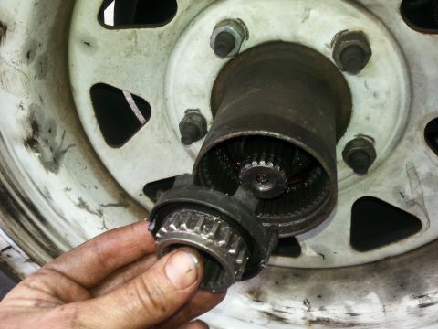 1981 Ford Bronco - A manual locking hub assembly is shown being removed from a vehicle's wheel hub.