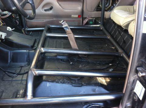1995 Ford Bronco - Custom roll cage installed inside a vehicle's interior, obscuring much of the original cabin.