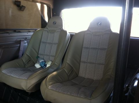 1995 Ford Bronco - The interior of the vehicle shows two aftermarket bucket seats with a patterned fabric insert.