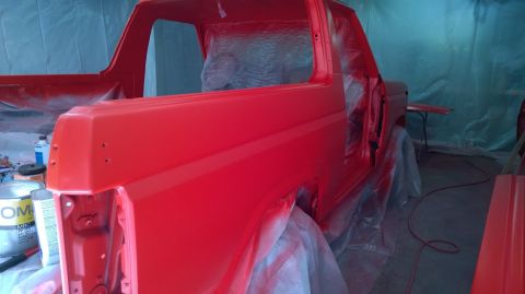 1983 Ford Bronco - Ford Bronco undergoing a fresh coat of red paint in a spray booth.