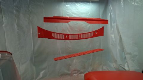 1983 Ford Bronco - Car parts painted red and hanging to dry in a spray booth.
