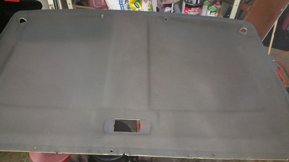 Gray vehicle headliner with a rectangular cutout and two D-ring mounting points