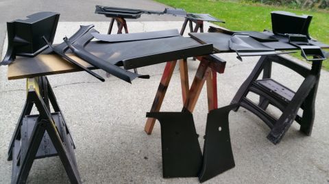 1983 Ford Bronco - Car interior trim pieces are laid out on sawhorses, likely for painting or drying.