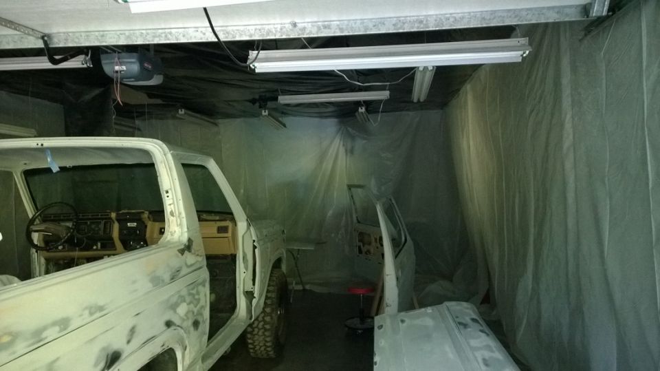 Truck cab and door removed, interior visible, another door and fender nearby