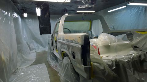 1983 Ford Bronco - A 1983 Ford Bronco is prepped for painting inside a spray booth, covered in protective plastic.