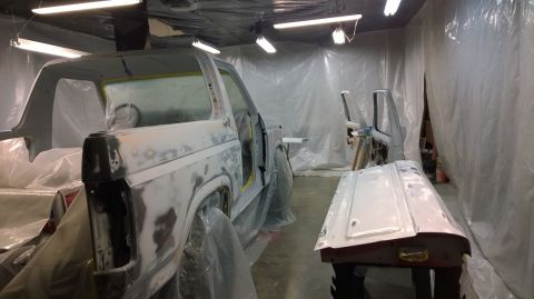 1983 Ford Bronco - Ford Bronco body undergoing preparation for painting inside a spray booth.