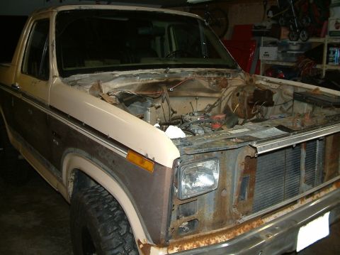 1983 Ford Bronco - This 1980s Ford Bronco shows its engine bay with the hood open. The vehicle exhibits significant rust on its front end.