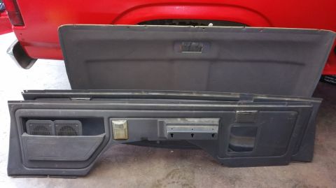 1983 Ford Bronco - Interior panels from a vehicle are displayed, with a red vehicle's rear visible in the background.
