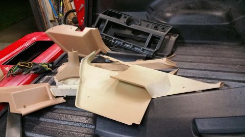 1983 Ford Bronco - Interior car parts are piled in the bed of a truck.