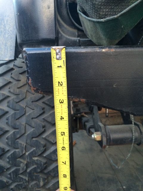 1987 Suzuki Samurai - A yellow measuring tape is placed against the black frame of a vehicle, indicating a measurement.