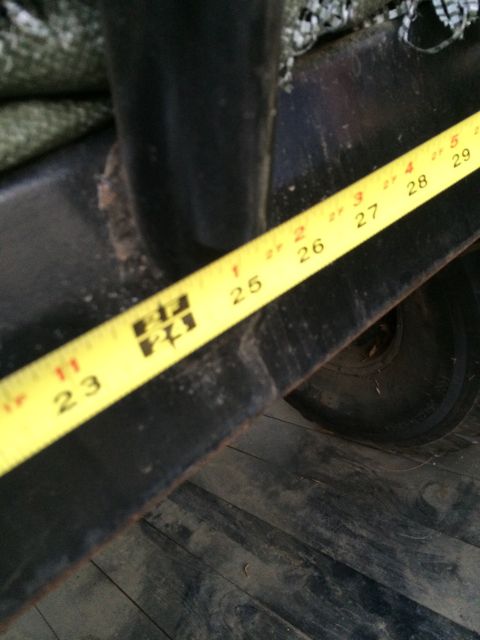 1987 Suzuki Samurai - A yellow measuring tape is positioned over a black metal frame, with a tire visible in the background.