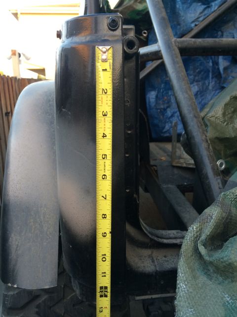 1987 Suzuki Samurai - A close-up of a vehicle's tailgate hinge is shown with a measuring tape for scale.