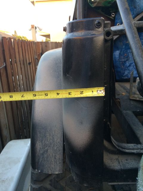 1987 Suzuki Samurai - A yellow measuring tape is placed against the black rear quarter panel and tail light assembly of a vehicle.