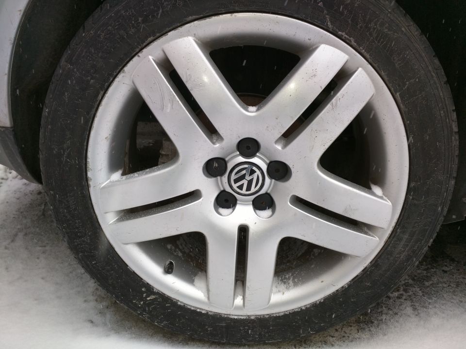 Volkswagen wheel with tire, showing the center cap with VW logo