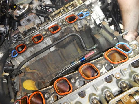 2002 Ford Mustang - Close-up of engine block showing removed intake manifold gaskets and a screwdriver.