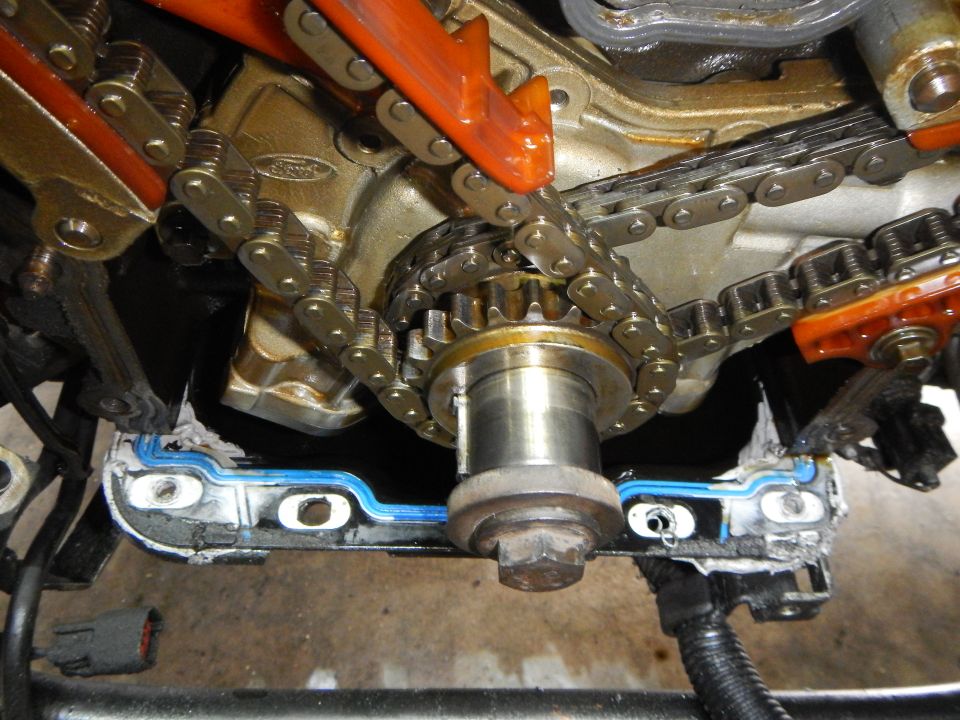 close-up of engine timing chain, gears, and tensioner assembly