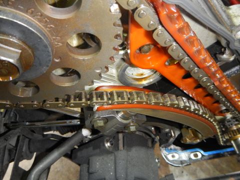 2002 Ford Mustang - Engine timing chain and gears with an orange tensioner guide visible.