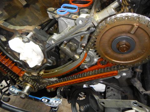 2002 Ford Mustang - Close-up view of engine timing components, including chains and sprockets, during a repair.