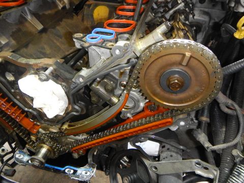 2002 Ford Mustang - Close-up view of engine timing components, including chains and sprockets, during a repair.