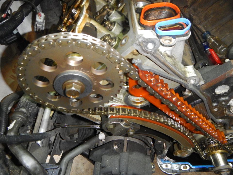 Close-up of engine timing chain, gears, and tensioner assembly