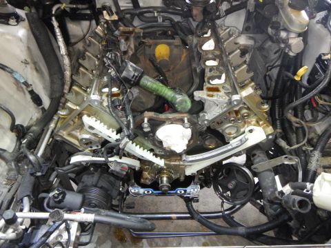 2002 Ford Mustang - The engine bay of a 2002 Ford Mustang is shown with the timing chain and gears exposed for replacement.