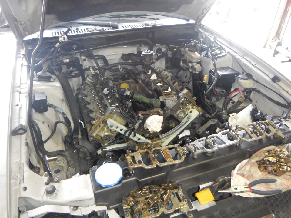 2002 Ford Mustang engine disassembled with parts laid out on a cloth