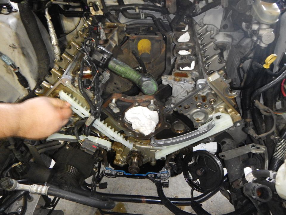 engine with timing chains exposed, hand working on it