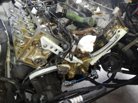 2002 Ford Mustang - Close-up view of an engine's timing chain and related components during a repair.