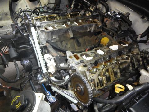 2002 Ford Mustang - Close-up view of an engine's timing chain and gears during a replacement procedure.