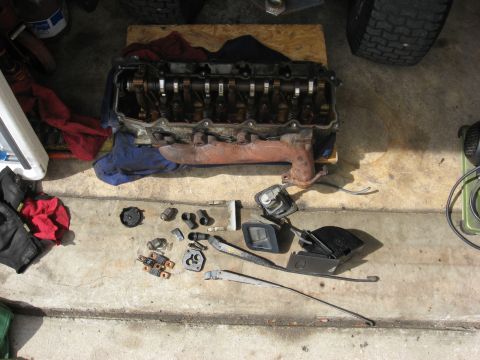 1994 Ford Bronco - Various engine components are disassembled and arranged on a concrete surface.