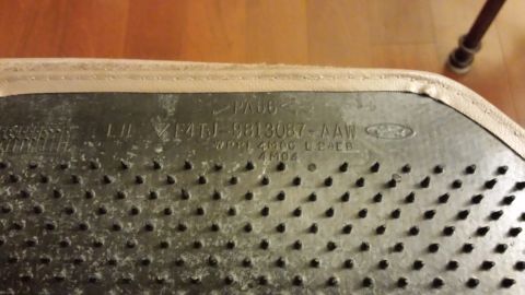 1995 Ford Bronco - Close-up of the underside of a Ford floor mat, showing part number and material information.