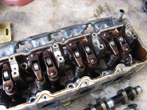 1994 Ford Bronco - Close-up view of an engine cylinder head, showing rocker arms and springs. Text from Supermotors.net is visible.