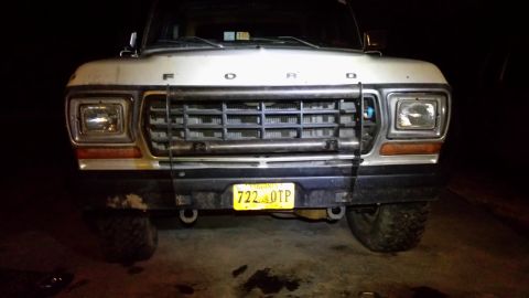 White 1979 Ford Bronco front view with a metal grille guard and yellow license plate