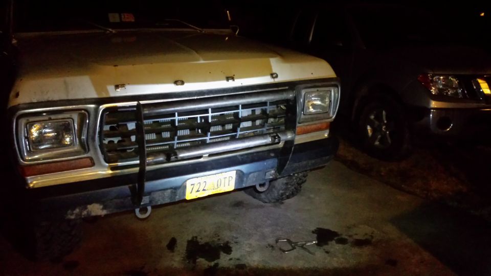 Front of a 1979 Ford Bronco with a grille guard. Another SUV is parked next to it