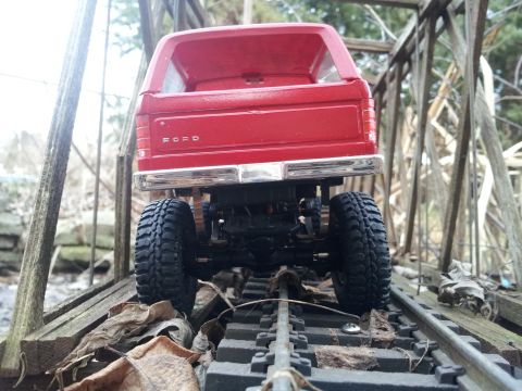 1995 Ford Bronco - This red Ford Bronco model is seen from the rear, positioned on a weathered wooden bridge.