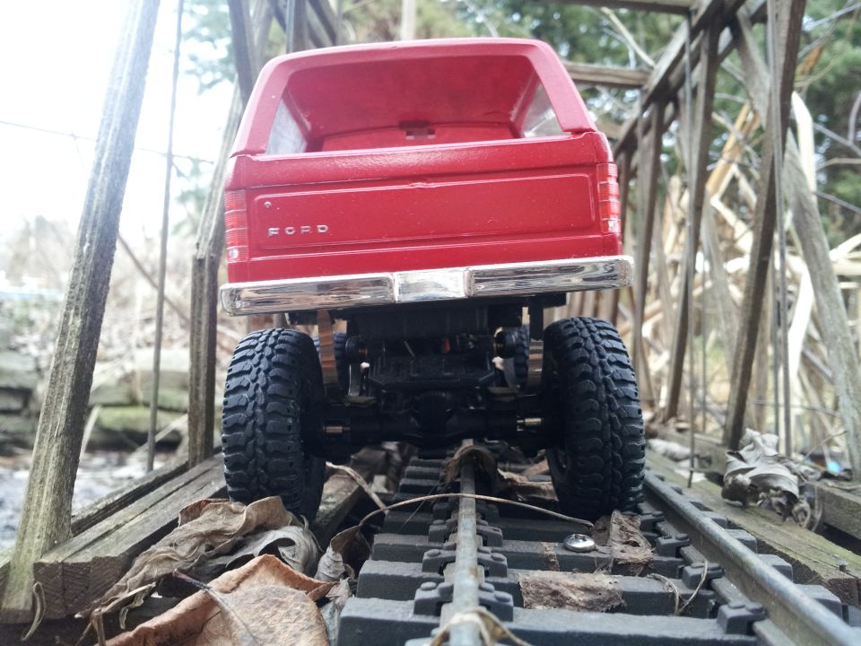 Red Ford Bronco model rear view on a wooden bridge