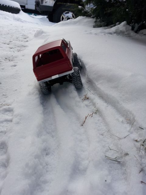 1995 Ford Bronco - A remote-controlled truck navigates a snowy terrain, leaving tire tracks behind.