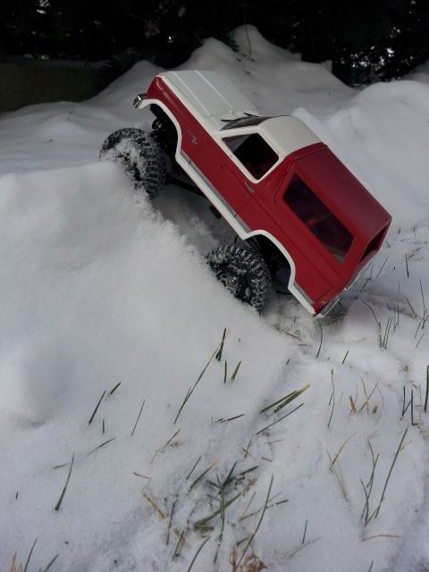 1995 Ford Bronco - A toy SUV navigates a snowy terrain, its red body contrasting with the white snow.