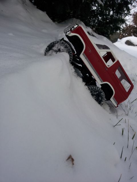 1995 Ford Bronco - A remote-controlled car navigates a snowy incline, with its tires partially buried.