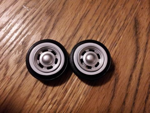 1995 Ford Bronco - Model car wheels with whitewall tires and chrome hubcaps are displayed on a wooden surface.