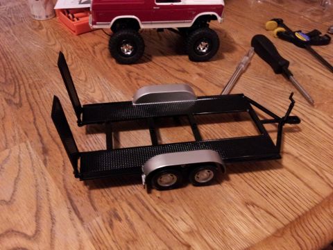 1995 Ford Bronco - A model truck and trailer are assembled on a wooden surface, with tools nearby.