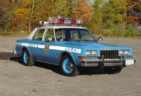 1991 Ford Crown Victoria - This police car, marked "POLICE" and "HWY 3", features a distinctive light bar and blue wheels.