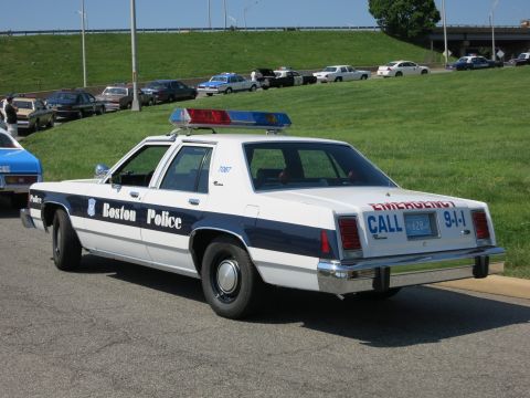 1991 Ford LTD Crown Victoria - Boston Police car with emergency lights on top, parked on a street.
